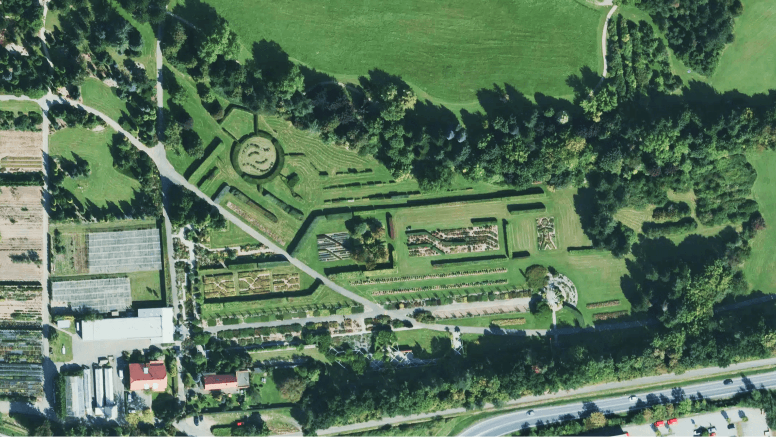 High-resolution aerial imagery of the geometric garden paths and outdoor play areas at the Dendrological Garden in Průhonice near Prague.